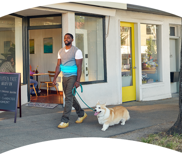 A man walking his dog on a sidewalk