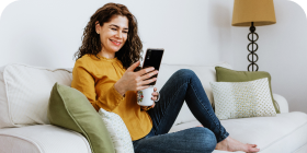 Woman drinking coffee using her smartphone