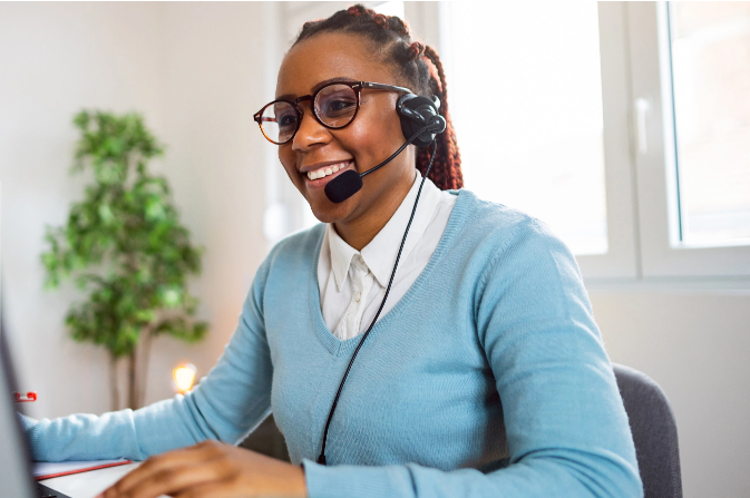 Smiling woman working at a desk with a headset on