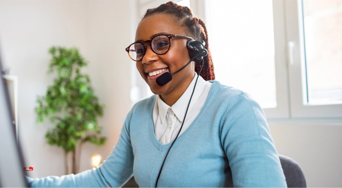 Smiling woman working at a desk with a headset on