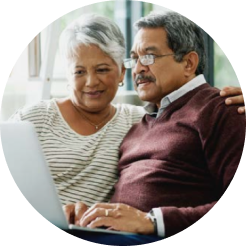 Man and woman sitting down and looking at a laptop