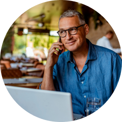 Man in blue shirt, wearing glasses, and talking on a cell phone