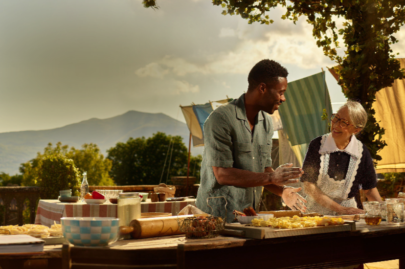 Man and woman happily cooking together outside