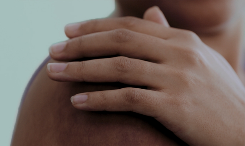 A person's hand on their shoulder
