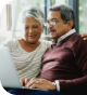 Man and woman sitting down and looking at a laptop