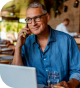 Man in blue shirt, wearing glasses, and talking on a cell phone