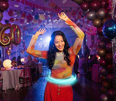 Paciente femenina con colitis ulcerosa (CU) tratada con TREMFYA®, bailando y divirtiéndose en su fiesta de cumpleaños número 60.