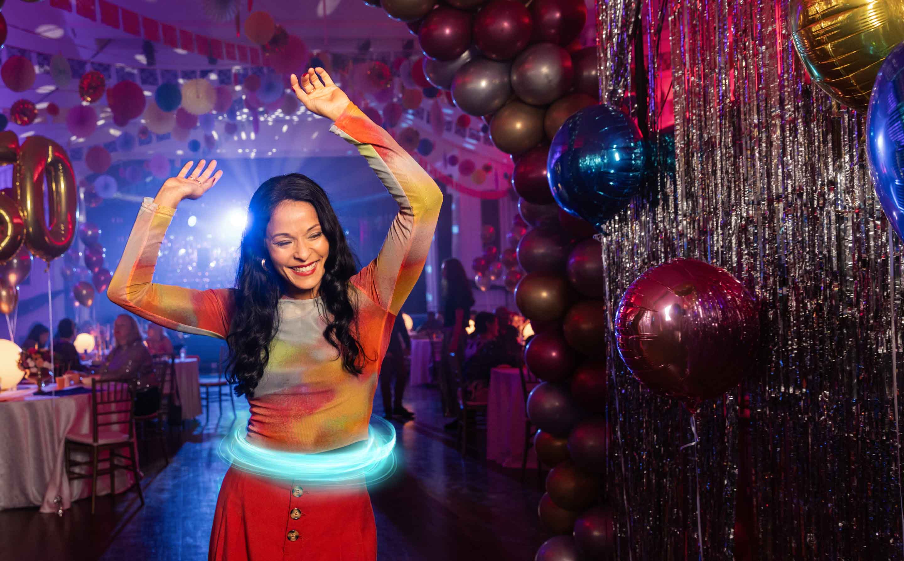 Paciente femenina con colitis ulcerosa (CU) tratada con TREMFYA®, bailando y divirtiéndose en su fiesta de cumpleaños número 60.